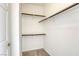 This walk-in closet has two shelves with dark brown trim and bright white walls at 2117 Echo Bay St # 102, Las Vegas, NV 89128