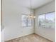 Inviting dining area featuring a charming chandelier, plush carpeting, and sunny windows at 2117 Echo Bay St # 102, Las Vegas, NV 89128