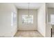 Bright dining area featuring carpeted floors, a charming chandelier, and a sun-filled window at 2117 Echo Bay St # 102, Las Vegas, NV 89128