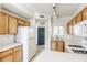 Modern kitchen with oak cabinets, white countertops, appliances, and tile flooring with backyard views at 2117 Echo Bay St # 102, Las Vegas, NV 89128