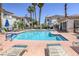 Beautiful community pool surrounded by lounge chairs and tropical palm trees at 2117 Echo Bay St # 102, Las Vegas, NV 89128