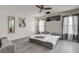 Bedroom with modern ceiling fan, art, gray laminate flooring, and natural light at 2130 Trebbiano Way, Las Vegas, NV 89156