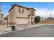 Exterior view of a two-story home with a stucco exterior, garage, and tidy landscaping in a suburban setting at 2130 Trebbiano Way, Las Vegas, NV 89156