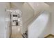 Hallway with stairs leading up, showcasing a glimpse of a well-lit kitchen with modern appliances at 2130 Trebbiano Way, Las Vegas, NV 89156