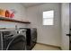 Functional laundry room with modern washer and dryer set, tile floor, and shelving unit at 2130 Trebbiano Way, Las Vegas, NV 89156