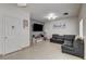 Bright living room with modern decor, tile floors, a gray accent wall, and a comfortable sectional sofa at 2130 Trebbiano Way, Las Vegas, NV 89156