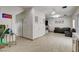 Open-concept living room with tile flooring, neutral tones, bar, and an access door for convenience at 2130 Trebbiano Way, Las Vegas, NV 89156