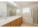 Bright bathroom featuring double sinks, soaking tub, and glass-enclosed shower for a luxurious experience at 2219 Sawtooth Mountain Dr, Henderson, NV 89044