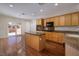 Charming kitchen with wood cabinets, granite countertops, stainless appliances, and an island at 2219 Sawtooth Mountain Dr, Henderson, NV 89044