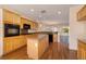 The kitchen features wood cabinets, granite countertops, and hardwood floors, adjacent to the dining and living areas at 2219 Sawtooth Mountain Dr, Henderson, NV 89044