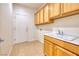 Practical laundry room featuring ample cabinet space and a utility sink for added convenience at 2219 Sawtooth Mountain Dr, Henderson, NV 89044