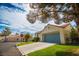 A ranch-style home boasts a blue garage door, desert landscaping, and a well-maintained lawn at 2251 Van Gogh Dr, Henderson, NV 89074
