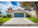 Ranch-style home featuring a spacious driveway, a blue two-car garage door, and well-manicured lawn at 2251 Van Gogh Dr, Henderson, NV 89074