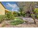 Well-manicured backyard featuring mature trees, artificial turf, and rock accents at 2295 Otter Rock Ave, Henderson, NV 89044