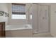 Bathroom featuring a soaking tub with tile surround and glass shower at 2295 Otter Rock Ave, Henderson, NV 89044