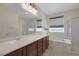Bathroom featuring double sinks, large mirror, tub, and glass enclosed shower at 2295 Otter Rock Ave, Henderson, NV 89044