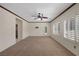 Spacious carpeted bedroom with plantation shutters, ceiling fan, and outside access at 2295 Otter Rock Ave, Henderson, NV 89044
