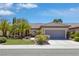 Charming single-story home featuring a well-manicured lawn, mature palm trees, and a two-car garage at 2295 Otter Rock Ave, Henderson, NV 89044