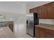 Kitchen with stainless steel refrigerator and granite countertops adjacent to the living area at 2295 Otter Rock Ave, Henderson, NV 89044