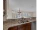 Kitchen sink with granite countertops and view to the chandelier-lit room at 2295 Otter Rock Ave, Henderson, NV 89044