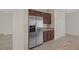 Stainless steel refrigerator with matching dark wood cabinets and granite countertops at 2295 Otter Rock Ave, Henderson, NV 89044