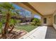 Covered patio overlooking a landscaped backyard with lush greenery and mature palm trees at 2295 Otter Rock Ave, Henderson, NV 89044