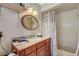 Bathroom featuring a vanity with a granite countertop, sink, oval mirror, and tiled shower at 2325 Sombrero Dr, Las Vegas, NV 89169
