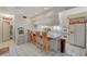 Bright, eat-in kitchen featuring vintage bar seating, white appliances, and ample counter space at 2325 Sombrero Dr, Las Vegas, NV 89169