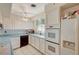 Close-up view of the kitchen featuring white cabinets, appliances, and a window with blue curtains at 2325 Sombrero Dr, Las Vegas, NV 89169