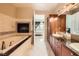 Relaxing bathroom featuring a soaking tub with fireplace, dual vanity, and walk-in closet at 2455 W Serene Ave # 923, Las Vegas, NV 89123