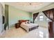 A stylish bedroom featuring light green paint, dark brown curtains, and light marble floors at 2455 W Serene Ave # 923, Las Vegas, NV 89123