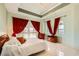 Bright bedroom featuring red curtains, a decorative ceiling, and large windows at 2455 W Serene Ave # 923, Las Vegas, NV 89123