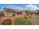 Wide shot of the backyard featuring desert landscaping, trees, and a covered patio at 2571 Thatcher Ave, Henderson, NV 89052