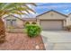 Charming single-story home showcasing desert landscaping, a two-car garage, and a well-manicured lawn at 2571 Thatcher Ave, Henderson, NV 89052
