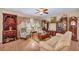Spacious living room with a ceiling fan, hard wood floors, large windows, and plenty of furniture at 2571 Thatcher Ave, Henderson, NV 89052