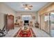Living room with tile floor, ceiling fan, and sliding glass doors to the backyard at 2571 Thatcher Ave, Henderson, NV 89052