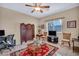 Cozy living room with tile floors, a ceiling fan, area rug and a classic wood screen for decor at 2571 Thatcher Ave, Henderson, NV 89052