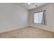 Empty bedroom with tile flooring, bright lighting, window with blinds, and neutral wall color at 2621 Ground Robin Dr, North Las Vegas, NV 89084