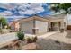 Inviting single-story home with a well-manicured yard, desert landscaping, and a two-car garage at 2621 Ground Robin Dr, North Las Vegas, NV 89084