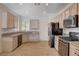 Well-lit kitchen featuring stainless steel appliances, light wood cabinets, and granite countertops at 2621 Ground Robin Dr, North Las Vegas, NV 89084