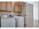 Well-equipped laundry room features modern Samsung washer and dryer, plus functional oak cabinetry at 2621 Ground Robin Dr, North Las Vegas, NV 89084
