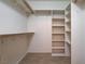 Spacious walk-in closet features custom shelving, closet rods, and tile flooring at 2621 Ground Robin Dr, North Las Vegas, NV 89084