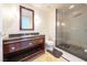 Modern bathroom with granite countertop, wood cabinet and glass enclosed walk-in shower at 2700 Las Vegas Blvd # 2809, Las Vegas, NV 89109