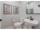 Elegant half-bathroom with stylish pedestal sink and decorative artwork at 2862 Sapphire Desert Dr, Henderson, NV 89052
