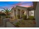 Charming home entrance with desert landscaping, stone walkway, and arched architectural details at sunset at 2862 Sapphire Desert Dr, Henderson, NV 89052