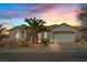 Charming single-story home with a two-car garage, desert landscaping, and a majestic palm tree at sunset at 2862 Sapphire Desert Dr, Henderson, NV 89052