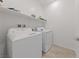 Laundry room features a side-by-side washer and dryer setup with a shelf for storing laundry supplies at 31 Strada Loreto, Henderson, NV 89011