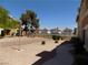 View of desert backyard with small bushes, rock landscaping and condo buildings in the distance at 3890 Terrazzo Ave, Las Vegas, NV 89115