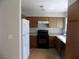 Functional kitchen featuring wood cabinetry, white appliances, and ample counter space for cooking at 3890 Terrazzo Ave, Las Vegas, NV 89115
