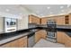 Well-equipped kitchen with stainless appliances, dark countertops, and natural wood cabinets at 3930 University Center Dr # 202, Las Vegas, NV 89119